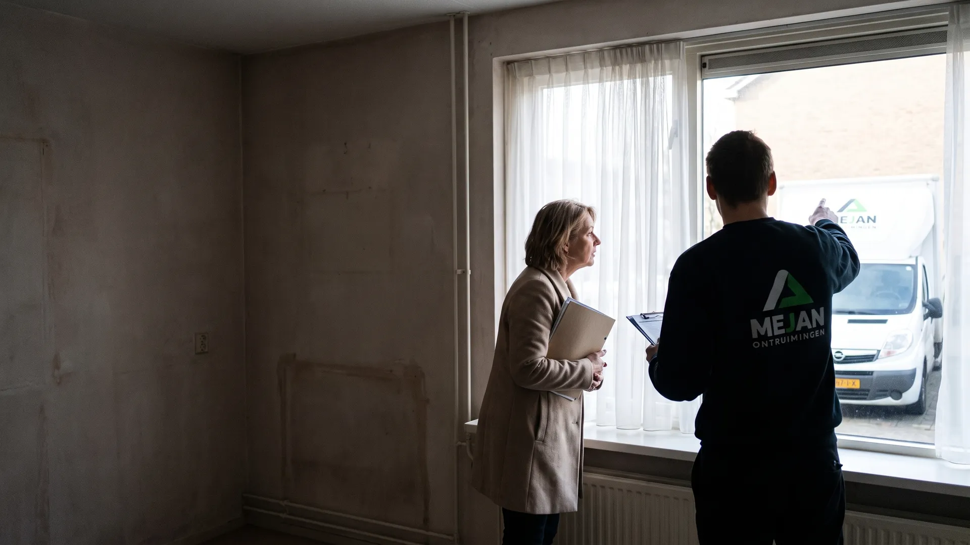 Medewerker neemt met de verhuurder de lege huurwoning door bij het raam
